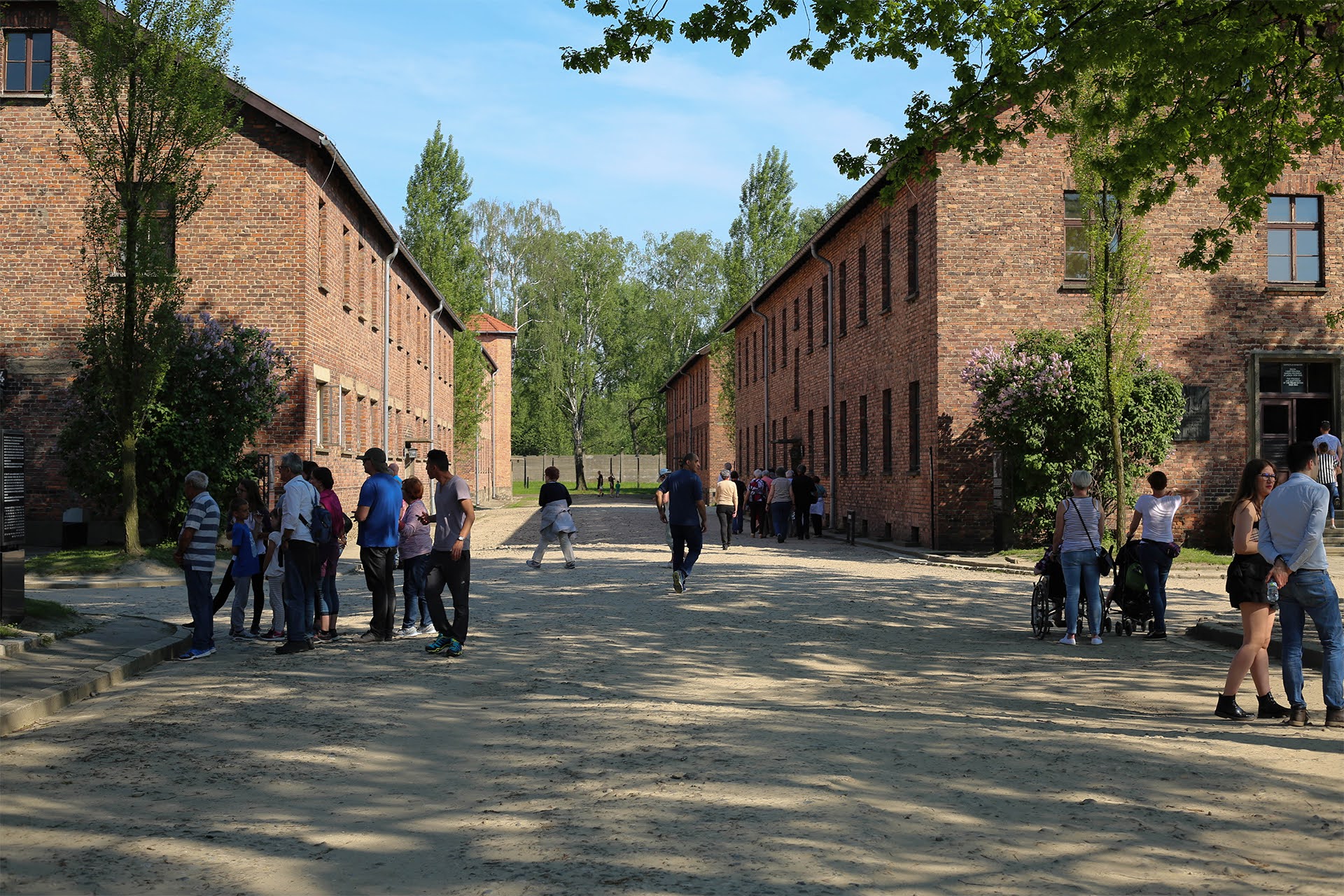 Visitors walking between brick barracks