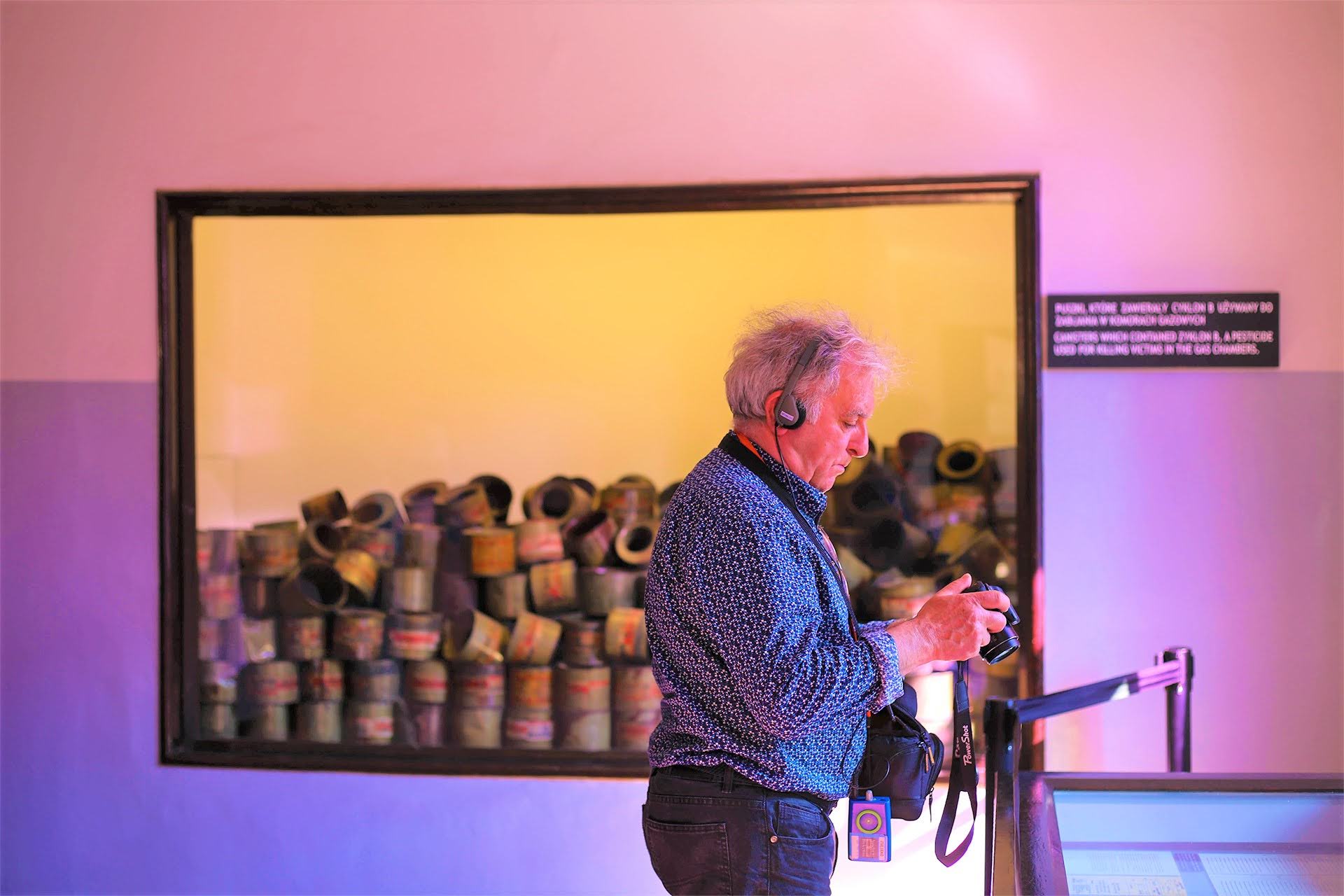 Visitor beside display of Zyklon B canisters used in the gas chambers